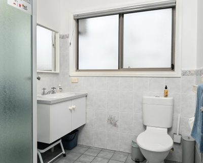 The contemporary bathroom of Bayview Apartment at Emu Bay Holiday Homes, featuring modern fixtures, a spacious shower, and elegant decor, providing guests with a comfortable and stylish space to refresh and relax during their stay.