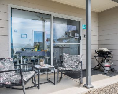 The inviting patio of Bayview Apartment at Emu Bay Holiday Homes, overlooking the tranquil surroundings with a view of the bay, furnished with comfortable seating and surrounded by lush greenery, offering guests a serene outdoor space to enjoy the natural beauty.