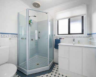 A contemporary bathroom inside Cottage 3 at Emu Bay Holiday Homes, featuring modern fixtures, clean lines, and tasteful decor, providing a comfortable and stylish space for guests to refresh and unwind during their stay.
