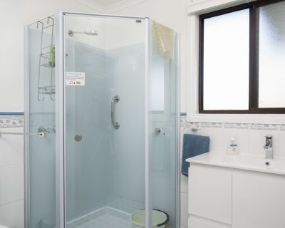 The modern bathroom of Cottage 4 at Emu Bay Holiday Homes, featuring contemporary fixtures, a spacious shower, and elegant decor, providing a comfortable and stylish space for guests to refresh and unwind.