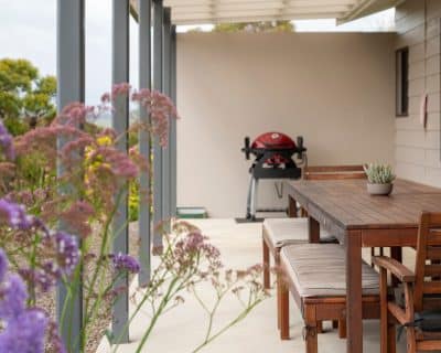 The inviting patio of Jireh House at Emu Bay Holiday Homes, offering a charming outdoor space with comfortable seating, surrounded by lush greenery, providing a perfect spot for guests to relax and enjoy the tranquil surroundings.