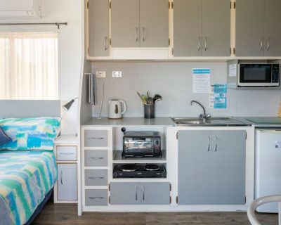 The rustic kitchen of Rustic Cabin 1 and 2at Emu Bay Holiday Homes, providing guests with a charming and functional space to prepare meals and enjoy the rustic ambiance.